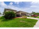 Side view of the house showing additional landscaping and driveway at 4617 Harvest Row Ln, St Cloud, FL 34772