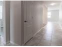 Bright hallway with light grey tiled floor and white doors at 4617 Harvest Row Ln, St Cloud, FL 34772