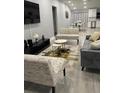 Spacious living room with gray sofa, patterned bench, and modern coffee tables at 943 Derbyshire Dr, Kissimmee, FL 34758