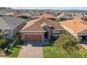 One-story house with a brown roof and a brick driveway at 125 Silver Maple Rd, Groveland, FL 34736