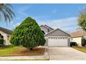 Two-story house with gray exterior and white garage door, plus a large tree at 12821 Gettysburg Cir, Orlando, FL 32837