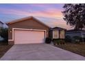 Two-car garage and front yard of a single-Gathering home at 1569 Tamarind Rd, Davenport, FL 33896