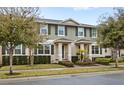 Two story townhome with green exterior, landscaping, and walkway at 16133 Pebble Bluff Loop, Winter Garden, FL 34787