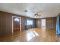 Living room with hardwood floors, wood paneling, and ceiling fan at 208 S Main Ave, Minneola, FL 34715