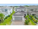 Two-story house, gray siding, gray garage, and a brick paver driveway; surrounded by other homes at 2438 Pearl Cider Street, Orlando, FL 32824