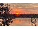 Stunning sunset over a tranquil lake with lush trees at 3250 Corona Village Way # 302, Orlando, FL 32835