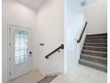 Bright entryway with tile flooring, stained glass door, and staircase at 459 Windmill Palm Cir, Altamonte Springs, FL 32701