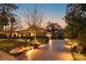 Stunning home exterior at dusk, featuring a brick driveway and professionally landscaped front yard at 812 Edgeforest Ter, Sanford, FL 32771