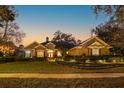 Beautiful single-story home at dusk with manicured landscaping, lush lawn, and glowing fountain at 812 Edgeforest Ter, Sanford, FL 32771