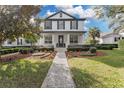 Two-story house with a brick pathway, lush landscaping, and a welcoming front porch at 11413 Camden Park Dr, Windermere, FL 34786