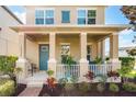 Two-story house with front porch, teal door, and manicured landscaping at 14694 Seton Creek Blvd, Winter Garden, FL 34787