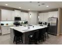 Modern kitchen with large island, white cabinets, and stainless steel appliances at 16368 Orange Seed Ln, Winter Garden, FL 34787