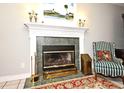 A cozy fireplace featuring an ornate mantel, decorative sconces, and an emerald green tile surround at 1821 Stanley St, Longwood, FL 32750