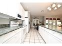 Long kitchen with white cabinets, granite counters and stainless steel appliances at 1821 Stanley St, Longwood, FL 32750