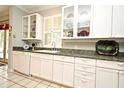 White kitchen with granite countertops and glass-front cabinets at 1821 Stanley St, Longwood, FL 32750