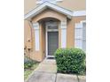 Townhome entry with dark green door and well-manicured shrubs at 1976 Estancia Cir # 1976, Kissimmee, FL 34741