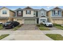 Row of townhouses with attached garages and neatly landscaped yards at 2583 Sedge Grass Way, Orlando, FL 32824