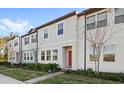 Two story townhome with orange door and neutral colored siding at 3092 Water Sprite St, Orlando, FL 32808