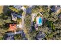 Aerial view showcasing a private backyard swimming pool nestled among mature trees in a residential neighborhood at 3442 Starbird Dr, Ocoee, FL 34761