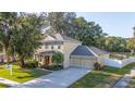 Attractive two-story house with a red front door, well-maintained landscaping, and an attached two-car garage at 3442 Starbird Dr, Ocoee, FL 34761