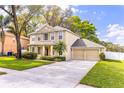 Beautiful two-story home with a spacious driveway and attached two-car garage nestled among mature trees at 3442 Starbird Dr, Ocoee, FL 34761