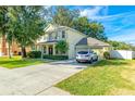 Charming two-story home featuring a manicured lawn, mature trees, and a welcoming columned front porch at 3442 Starbird Dr, Ocoee, FL 34761