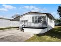 Front view of a white manufactured home with a carport at 50989 Highway 27 # 25, Davenport, FL 33897