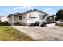 White manufactured home with a carport and small yard at 50989 Highway 27 # 25, Davenport, FL 33897