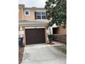 Townhome exterior with a brown garage door and small front yard at 538 Bexley Dr, Davenport, FL 33897