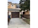 Front view of townhome featuring a brown garage door and walkway at 538 Bexley Dr, Davenport, FL 33897