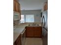 View of kitchen with wood cabinets, stainless steel appliances, and double sink at 538 Bexley Dr, Davenport, FL 33897