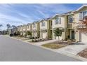 Row of tan townhomes with attached garages and landscaping at 54 Bella Oaks Dr, Port Orange, FL 32129