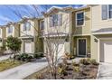 Tan two-story townhome with gray doors, attached garage, and landscaping at 54 Bella Oaks Dr, Port Orange, FL 32129