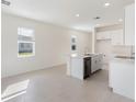 Open concept kitchen with island, white cabinets, and stainless steel appliances at 738 Lemon Ave, Fruitland Park, FL 34731