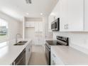 Modern kitchen featuring white cabinets, stainless steel appliances, and quartz countertops at 738 Lemon Ave, Fruitland Park, FL 34731