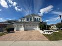 Two-story house with gray exterior, paver driveway, and landscaping at 3020 Cardillino Way, Kissimmee, FL 34741