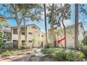 Charming exterior of a two-story residence surrounded by mature trees, a tile roof and walkway at 1000 Winderley Pl # 143, Maitland, FL 32751