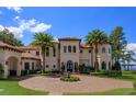 Elegant home features a circular driveway with a fountain, lush landscaping, and Mediterranean architecture at 11900 Lake Butler Blvd, Windermere, FL 34786