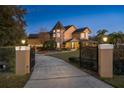 Elegant home at dusk with a gated entrance and landscape lighting at 1415 Brumley Rd, Chuluota, FL 32766