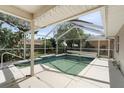 Relaxing screened-in pool area with a patio and surrounding greenery at 1423 Grand Cayman Cir, Winter Haven, FL 33884