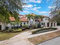 Stately two-story home boasts a clay tile roof, lush landscaping, and a long, curved driveway at 1446 Berkshire Ave, Winter Park, FL 32789