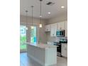 Modern kitchen with white cabinets, stainless steel appliances, and an island at 1545 Heritage Pl, Oviedo, FL 32765