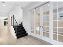 Modern entryway with black staircase and glass French doors at 2315 Depauw Ave, Orlando, FL 32804