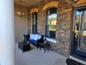 Cozy front porch with stone exterior, wicker furniture, and hanging light fixture at 3652 Chandler Estates Dr, Apopka, FL 32712