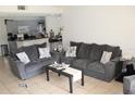 Living room with gray sofas, coffee table, and view of kitchen at 5271 Images Cir # 108, Kissimmee, FL 34746