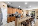 Well-equipped kitchen with light wood cabinets and a breakfast bar at 590 Michigan Estates Cir, St Cloud, FL 34769