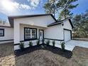 New construction home with white exterior, black accents, and a two-car garage at 702 Marion Oaks Manor, Ocala, FL 34473
