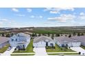 Three houses with gray roofs and green lawns; aerial view at 7149 Dilly Lake Ave, Groveland, FL 34736