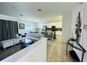 Open living room and kitchen with white cabinets and island at 840 Las Fuentes Dr, Kissimmee, FL 34746