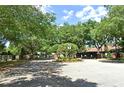 Gated community entrance featuring brick pillars, lush landscaping, and mature trees, offering a secure and welcoming atmosphere at 890 Moonluster Dr, Casselberry, FL 32707